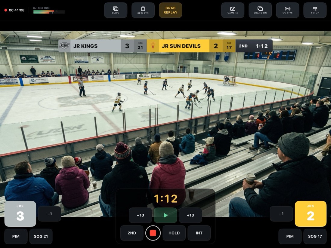 DadSportsNetwork running on iPad: a hockey game with the scoreboard burned into the picture, clips, replays and grab-replay controls across the top, score and clock controls along the bottom.
